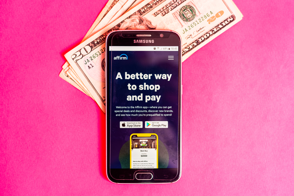 affirm app with money on pink table